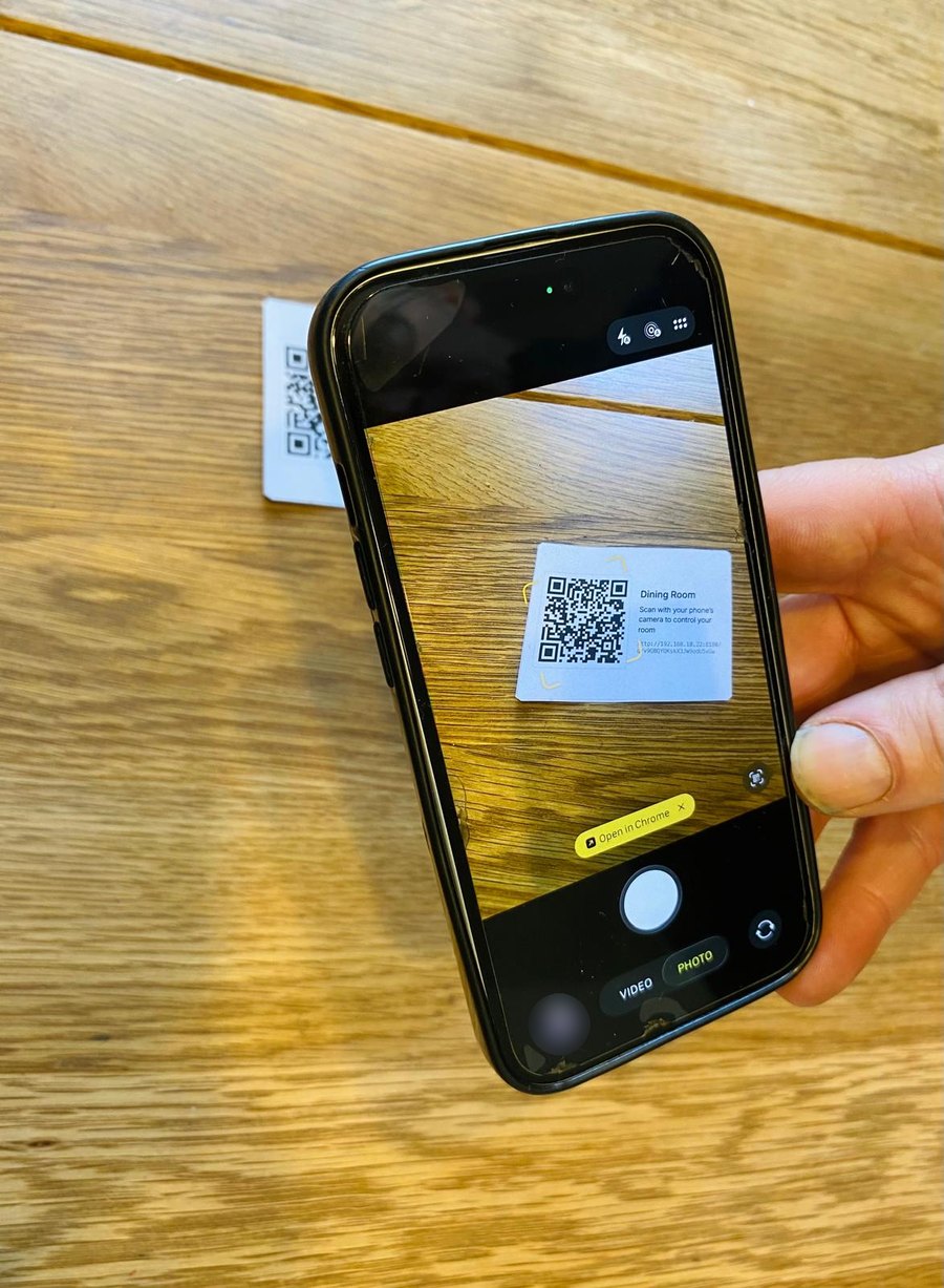 A phone's camera scanning a location's printed QR card, offering to open the link